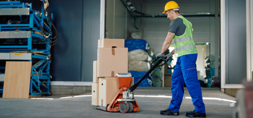 A man using a pallet truck to transport/move goods.
